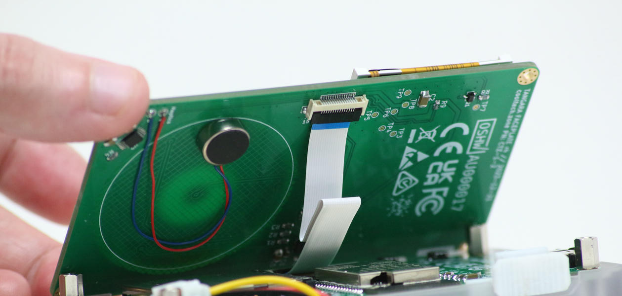 The faceplate is lifted slightly, revealing the ribbon cable and connector